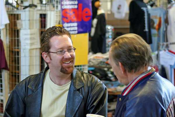 Brad St. Clair engaging in a heartfelt dialogue and sharing the message of Christ with a gentleman in a public setting.