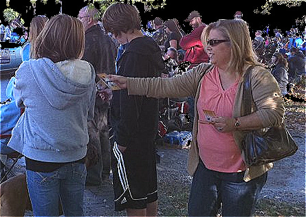 Leann smiles while offering a gospel tract, showing how faith-sharing tools start friendly conversations.